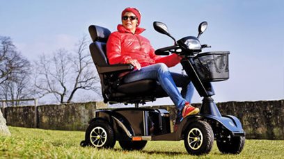 A woman stationary in a 4 wheel mobility scooter.